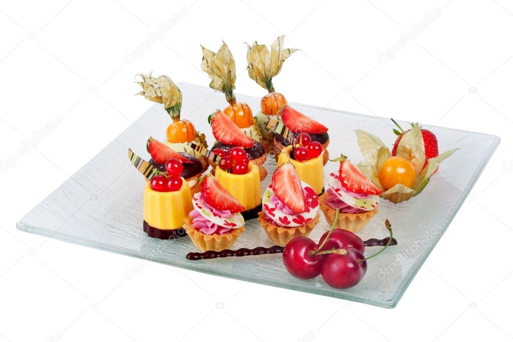 dish with mini chocolate cakes cream and berries