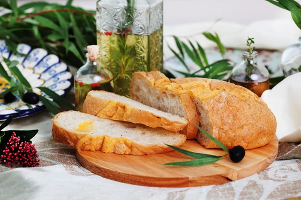 Ciabatta in still life on blackboard with olives and olive oil — Stock Photo, Image