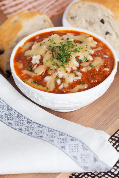 Горячий томатный суп с ложкой лука — стоковое фото