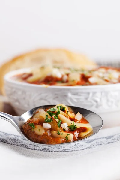 Горячий томатный суп с ложкой лука — стоковое фото
