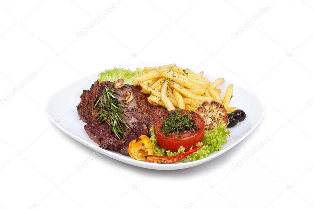 grilled steak with french fries and vegetables on the plate