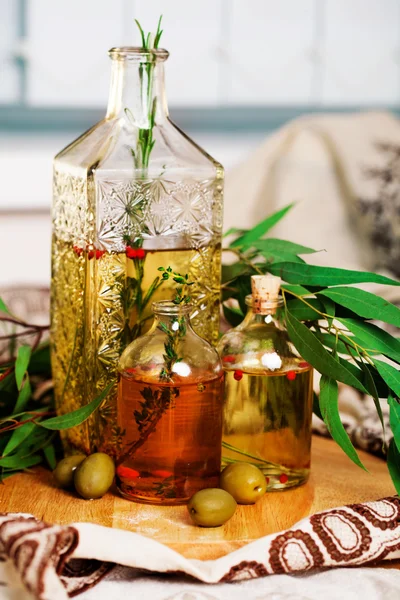 olive oil with rosemary and spices leaves, green olives still life