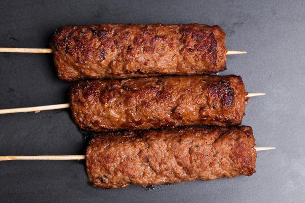 Lula kebab em espetos de madeira cozimento escuro — Fotografia de Stock