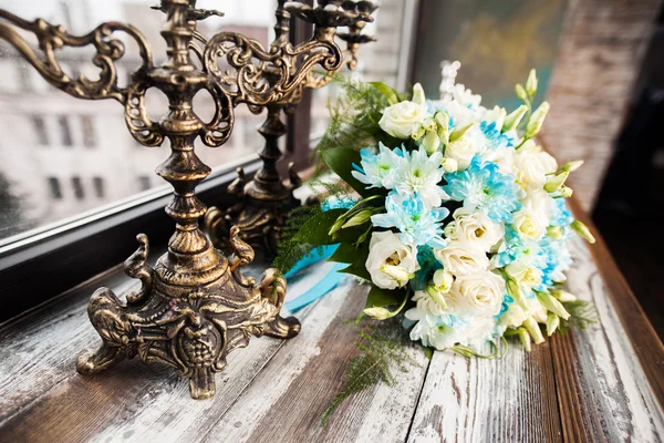 Beautiful wedding bouquet on a wooden table with vintage candlesticks — Stock Photo, Image