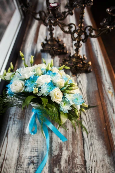 Beautiful wedding bouquet on a wooden table with vintage candlesticks — Stock Photo, Image