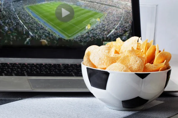 football bowl of chips at a computer with video broadcast sports fan