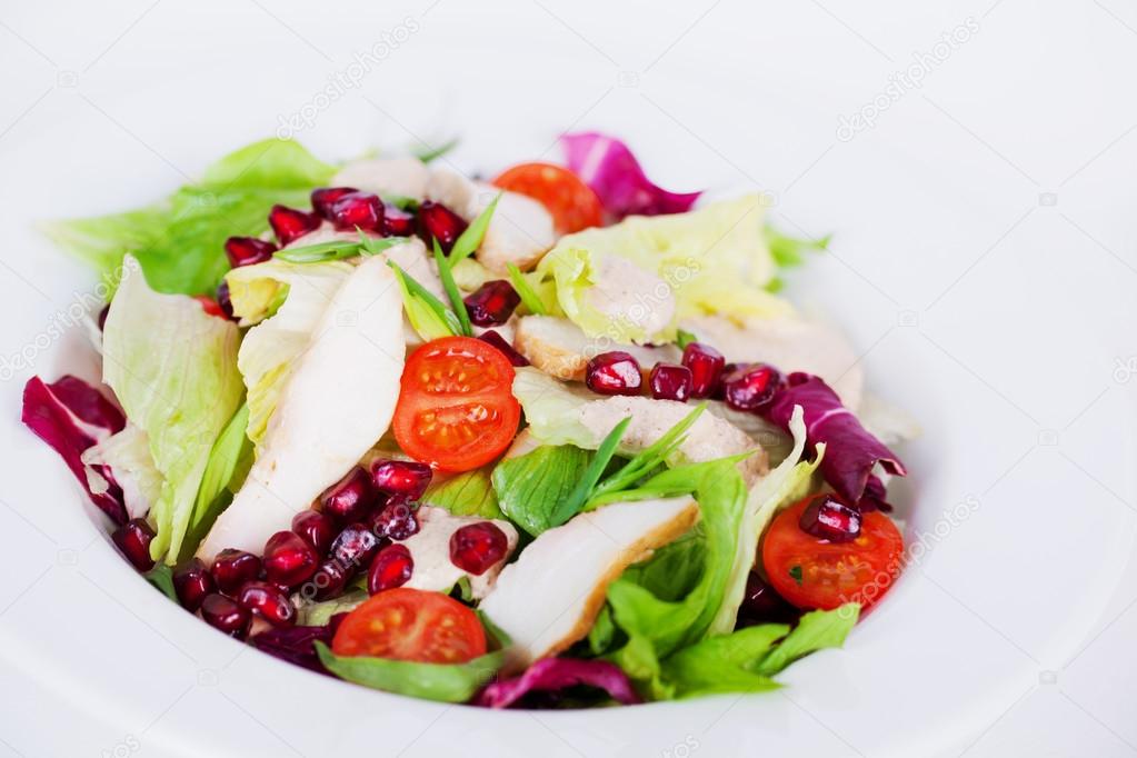 salad with chicken, iceberg lettuce, pomegranate closeup 