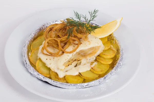 Pescado blanco con patatas, cebollas fritas, eneldo, limón en papel de aluminio en el —  Fotos de Stock