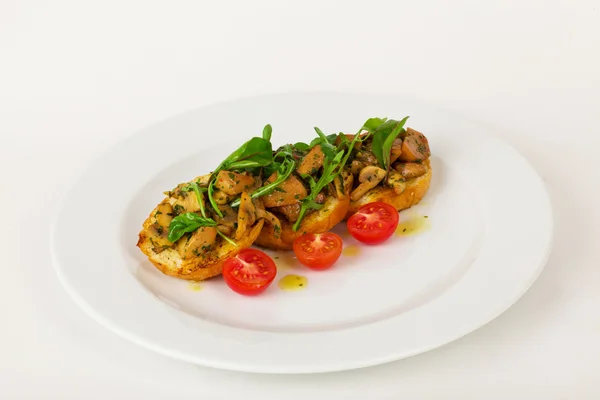 Bruschetta mit Champignons und Kirschtomaten Basilikum auf einem Teller isoliert für das Menü — Stockfoto