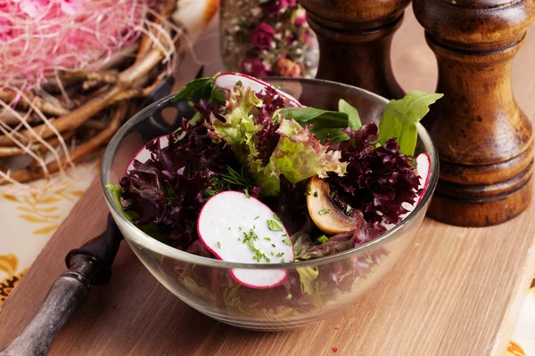 Salada com alface vermelha e tigela de vidro de rabanete mesa de madeira na natureza morta — Fotografia de Stock