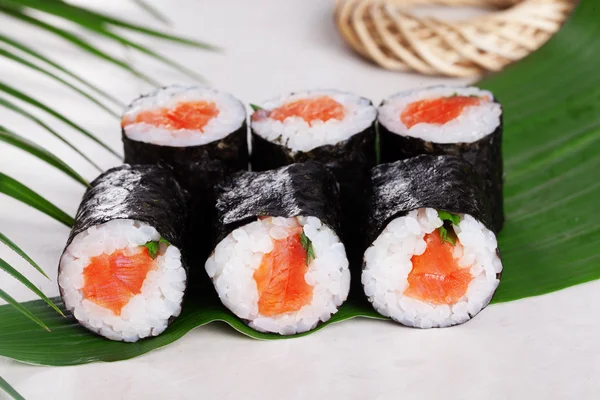 Rollo de sushi cebollino salmón mini kappa maki en la naturaleza muerta en hojas tropicales — Foto de Stock