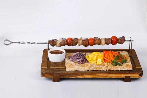 Brochetas de kebab de carne en una tabla de palos —  Fotos de Stock