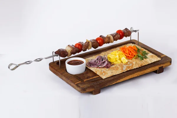 Brochetas de kebab de carne en una tabla de palos —  Fotos de Stock