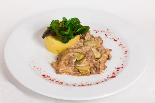 Beef goulash stroganoff with pickles and mashed potatoes on a plate isolated white background close-up — Stock Image Beef goulash stroganoff with pickles and mashed potatoes on a plate isolated white background close-up Stock Photo
