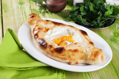 Acara khachapuri üç yumurta sarısı bıldırcın yumurtası yeşil bir tabakta hala hayatta