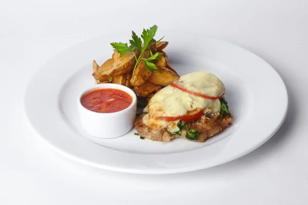 Жареное мясо с помидорами и майонезом, картофельные клинья в тарелке кожуры изолированное белое фоновое меню — стоковое фото