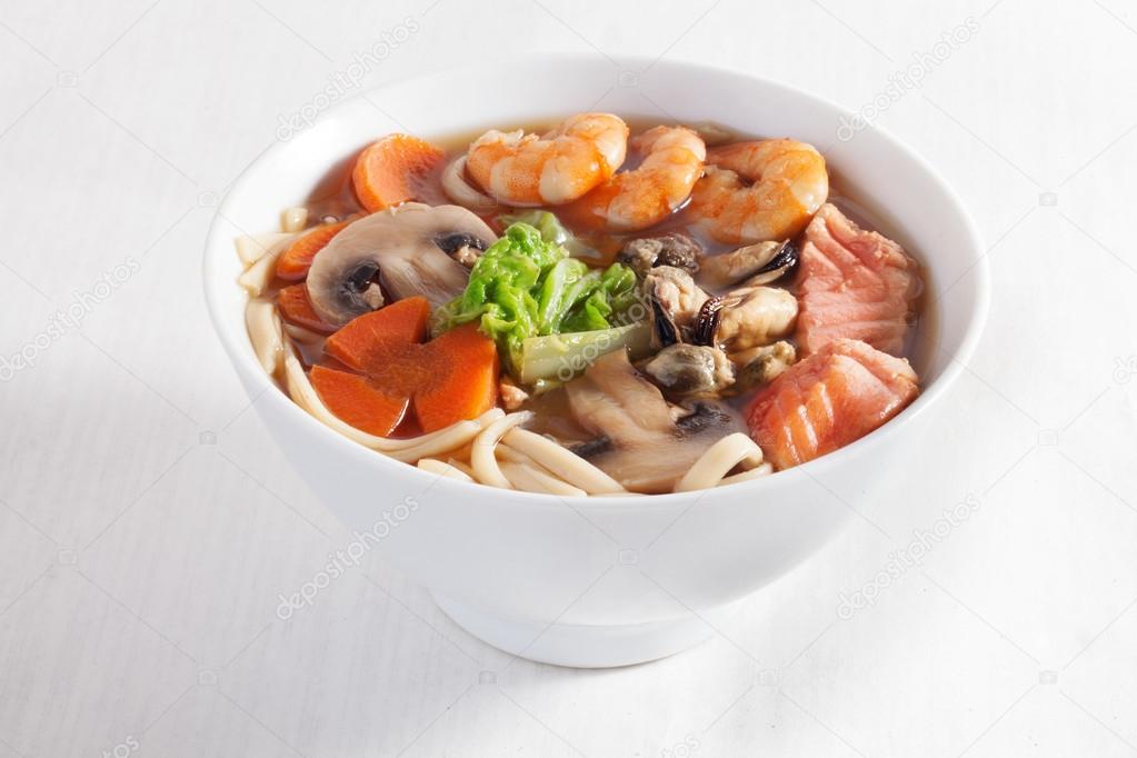 seafood soup shrimp mussels pasta fish mushrooms in a bowl isolated on white background