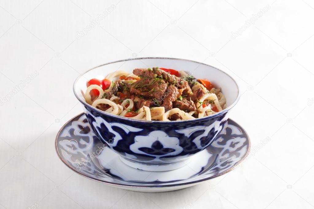Lagman with meat clay pot wooden board still life green bright beautiful appetizing, delicious food