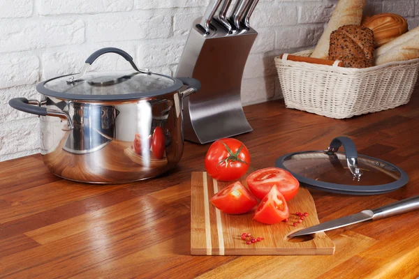 Tomates em uma faca de tábua de madeira bancadas de cozinha, interior, panela, fogão, fogão — Fotografia de Stock