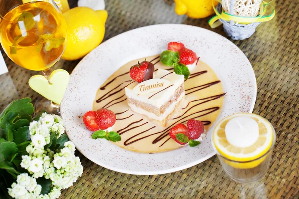 Tiramisu avec des fraises sur une assiette citron lettre table de service — Photo