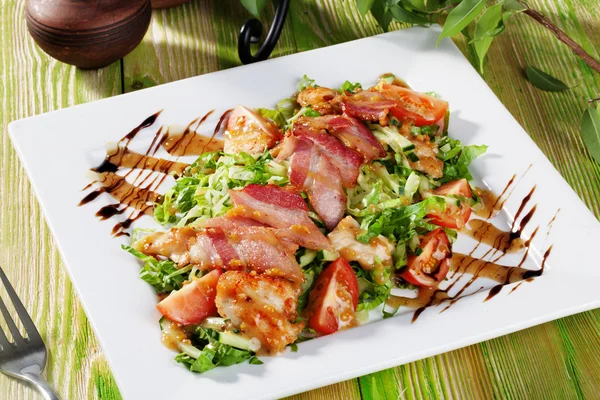 Ainda salada com pepitas de frango, arugula, bacon, tomates, molho balsâmico em uma mesa de madeira — Fotografia de Stock