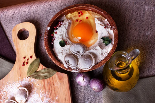 Ravioli di gnocchi, uova congelate, modellazione a mano, aglio da cucina, tavola, lino, foglie di alloro in cima, una bella natura morta — Foto Stock