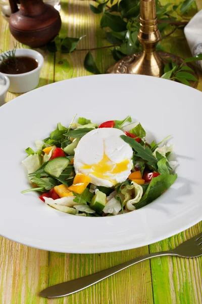 Salad with poached egg, cucumbers, arugula, cabbage, peppers, still life on a wooden table green chalkboard pretty food — Stock Photo, Image