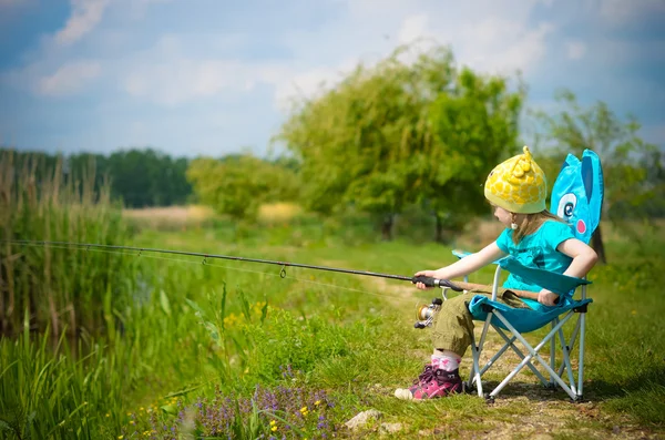 Schattig meisje vissen op het meer — Stockfoto