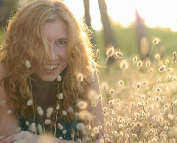 Retrato de uma bela menina de cabelos vermelhos rindo na grama — Fotografia de Stock