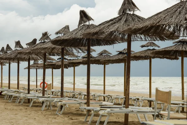 Багато парасольок на пляжі перед грозою — стокове фото