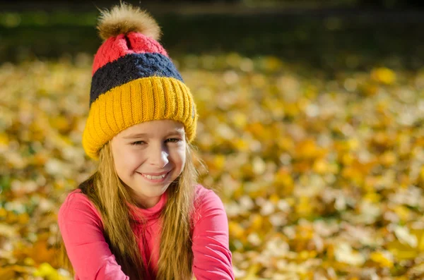 Bella ragazza sorridente con foglie gialle sullo sfondo — Foto Stock