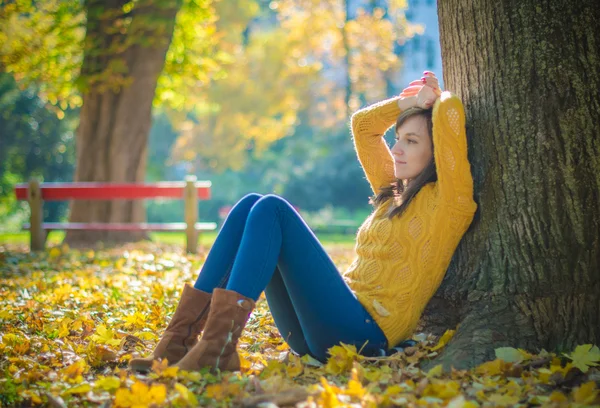 Bella donna seduta vicino al tronco d'albero e sognando — Foto Stock