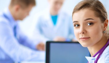 Tıp ekibi modern hastanedeki masada oturuyor.