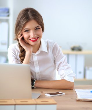 Ofiste masa başında oturan çekici bir iş kadını.