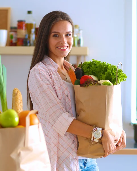 Young woman holding grocery shopping bag with vegetables — Stock Photo, Image