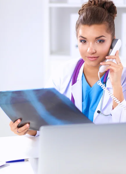 Junge Ärztin studiert Röntgenbild am Schreibtisch — Stockfoto