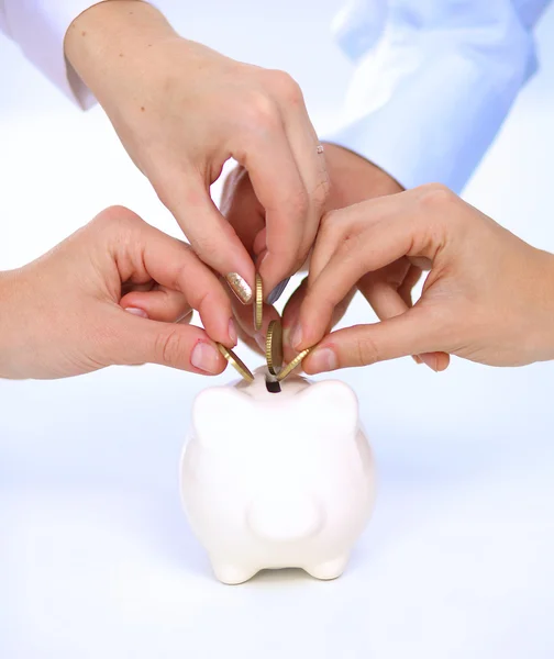 Mensen brengen munt in de piggy bank — Stockfoto