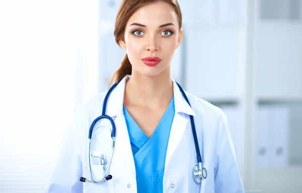 Portrait of young woman doctor with white coat standing in hospital — Stock Photo, Image