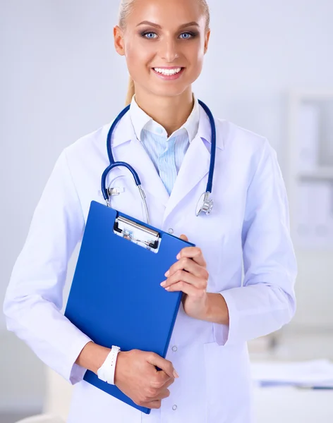 Zâmbind medic cu un dosar în uniformă în picioare la spital — Fotografie, imagine de stoc