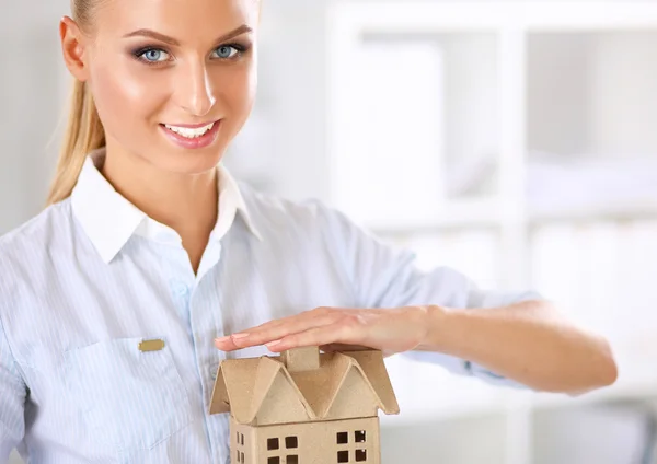 Portrait of female architect with blueprints at desk in office — Stock Photo, Image