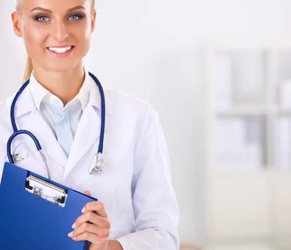 Smiling female doctor with a folder in uniform standing at hospital — Stock Photo, Image