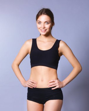 Gri arka plan üzerinde duran genç kadın