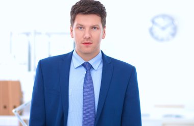 Ofiste masasının karşısında duran bir iş adamı ya da yönetici.