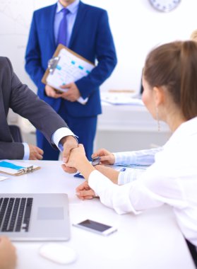 Business people shaking hands, finishing up a meeting, in office clipart