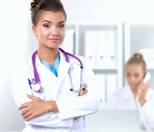 Portrait of young woman doctor with white coat standing in hospital — Stock Photo, Image