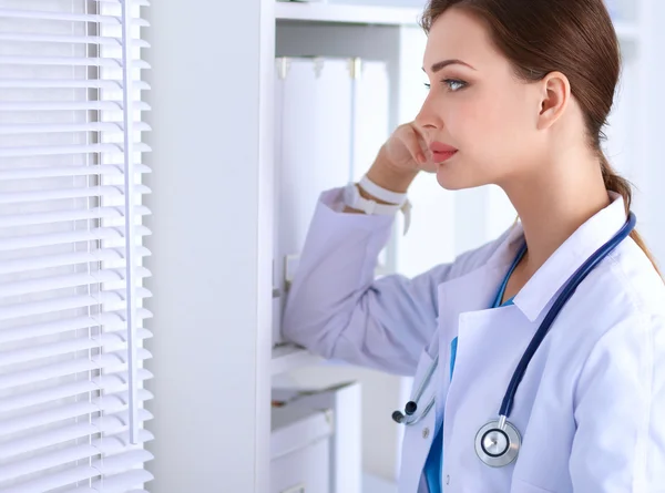 Portrait of young woman doctor with white coat standing in hospital — Stock Photo, Image