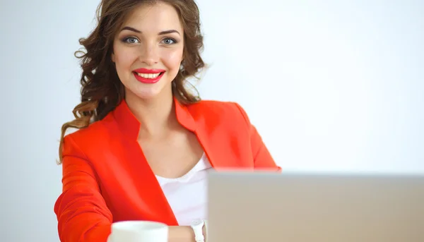 Attraktiv kvinna sitter vid skrivbordet på kontoret, arbetar med bärbar dator — Stockfoto