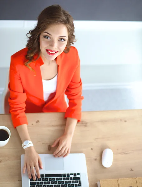 Attraktive Frau sitzt im Büro am Schreibtisch und arbeitet mit Laptop — Stockfoto