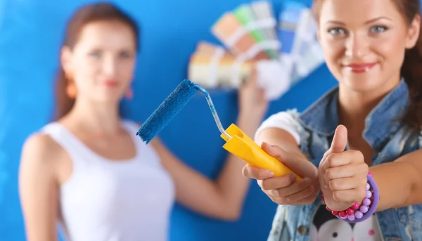 Dois bela jovem fazendo pintura de parede, sentado — Fotografia de Stock