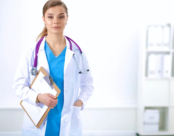 Woman doctor standing with folder at hospital — Stock Photo, Image